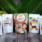 Product lineup of Meea's Food Products including Instant Latik spread, Ube Coco Pastillas, Coco Bites Cookies, Coco Power Bar, and Coco Kamote Candy on a wooden table
